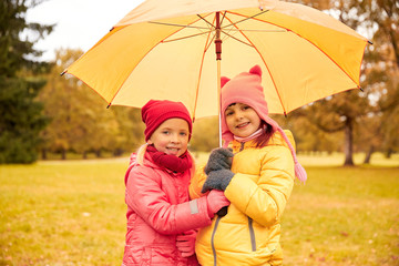 happy little girls with umbrella in autumn park