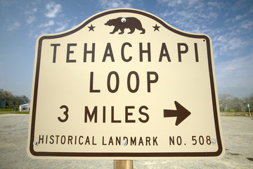 A monument sign from 1955 showing the Tehachapi Train Loop near Tehachapi California is the historic location of the Southern Pacific Railroad where freight trains gain 77 feet in elevation and show freight cars traveling in giant loop