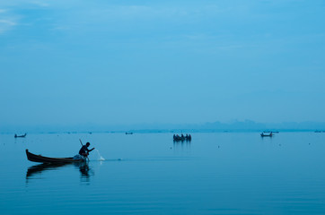 Fototapeta na wymiar Fisherman working with peaceful twilight sunset at Amarapura, U-Bein bridge, Mandalay, Myanmar