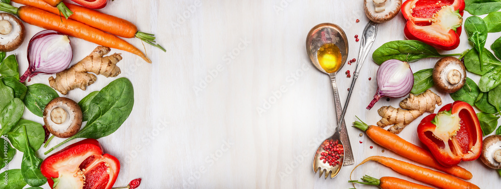 Sticker organic vegetables assorted with cooking spoons and oil on white wooden background