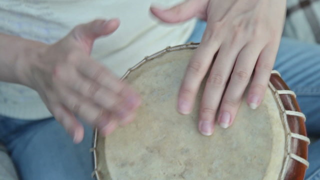 Women playing on Jambe Drum on nature