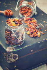 Granola, honey, raisins, peanuts and sunflower seeds, vintage suitcases.Toned image. Vintage style.selective focus