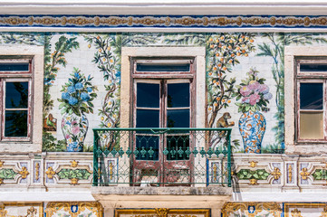 Balcony of a typical house in Portugal, decorated with ceramics that have flowers, fruits and animals, in Lisbon