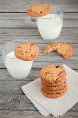 Chocolate and cranberry cookies with milk on the wooden table