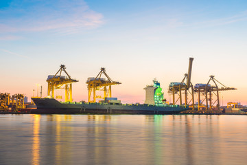 Container Cargo freight ship with working crane bridge in shipya