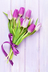 Purple tulips over wooden table