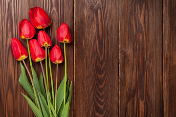 Red tulips bouquet over wood