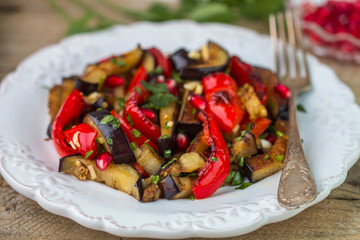 Salad of baked vegetables. Eggplant and bell peppers with pomegr