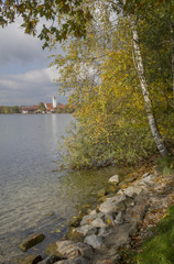 Fototapeta na wymiar Riegseeufer im Herbst, Blick zur Dorfkirche