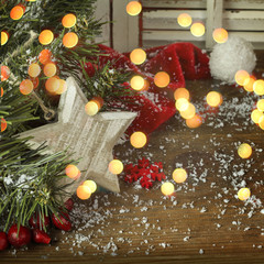 Christmas fir tree with  red hat and snow on a wooden background