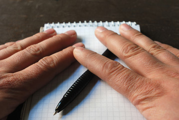 Fingers covered notebook page