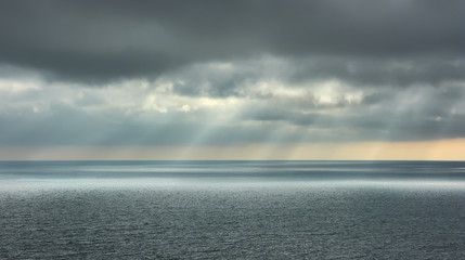 Beautiful seascape. Landscape with dramatic clouds over the sea and rays of sun.