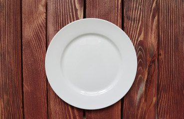 white empty plate on wooden table