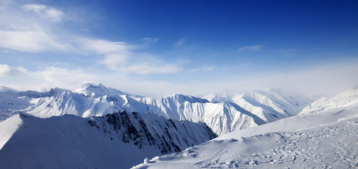 Panoramic view on snowy mountains at sun day