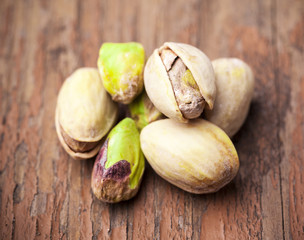 Pistachios with salt on wooden background