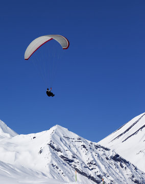 Paraglider in sunny snowy mountains at nice day