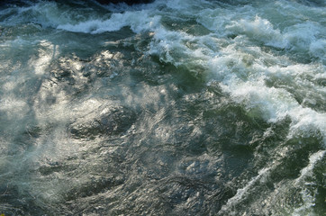 Fototapeta na wymiar Wild water in meltwater river in mountains