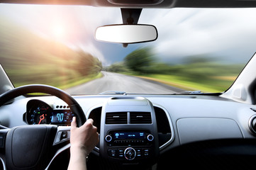 Driver's hands on steering wheel inside of a car