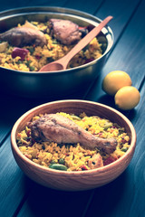 Toned image of chicken paella, a traditional Valencian (Spanish) rice dish made of rice, chicken, peas and capsicum, photographed with natural light