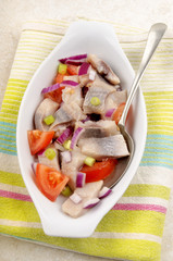 herring salad with tomato, purple onion and spring onions