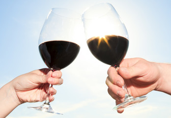 couple drinking a bottle of red wine outside