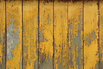 Восемь вертикальных досок с потрескавшийся краской желтого цвета