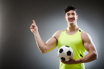 Muscular man with football ball