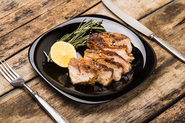 Sliced grill beefsteak served with lemon and rosemary