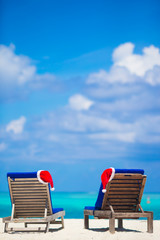 Christmas hats on beach loungers at white beach in Maldives