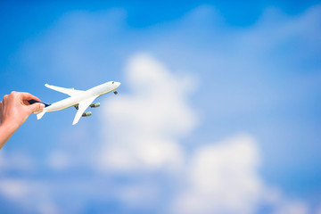 Fototapeta na wymiar Small white miniature of an airplane on background of blue sky