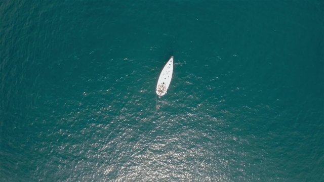 Aerial shot birds eye view of a isolated sailboat in the sea water