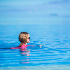 Fototapeta na wymiar Little happy adorable girl in outdoor swimming pool