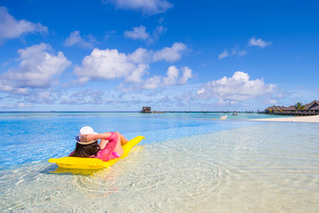 Young happy woman relaxing with air mattress on the beach