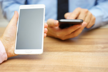 woman is holding big smart mobile phone with emtpy screen with b
