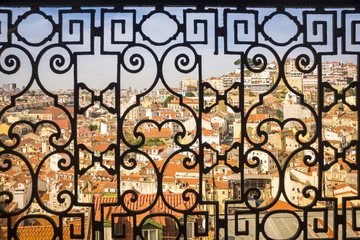a view over Lisbon, Portugal's capital, through the frame of a traditional balcony in the St. George castle's hill