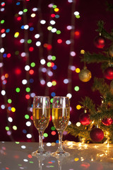 Two glasses of champagne near beautiful christmas tree