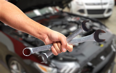 Hand of car mechanic in auto repair service. 