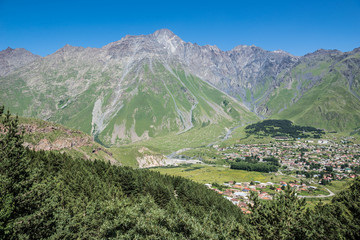 Fototapeta na wymiar Aerial view on Gergeti village and Stepantsminda town in Greater Caucasus Range, Georgia