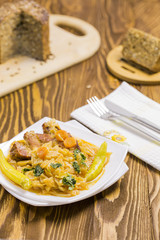 Cooked Cabbage with Carrots, Hot Peppers, Parsley, Integral Sunflower Bread on Brown Wooden Table