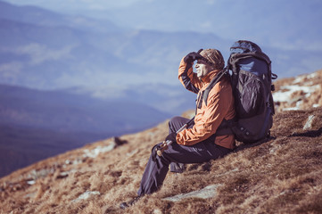 Man Traveler with Backpack hiking in Mountains with beautiful landscape