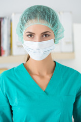 Fototapeta na wymiar Portrait of female surgeon wearing protective mask and cup