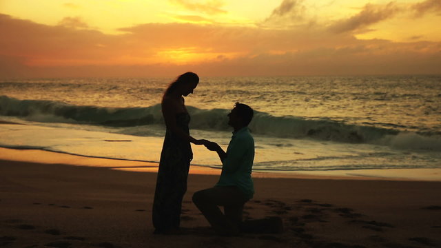 Man Proposing To Woman Sunset-Lit Beach