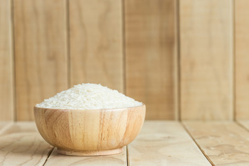 Thai jasmine rice in wooden bowl on wooden background