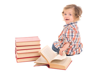 baby boy sitting near pile of books