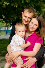 young happy family in summer outdoors