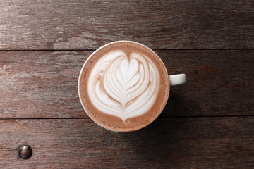 cup of latte art coffee on wooden background