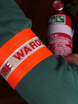 Fire warden with a reflective high visibility identification patch holding a fire extinguisher, Melbourne 2015