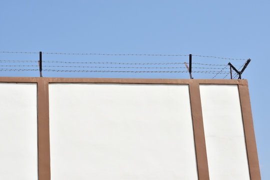 Prison wall and wire barbs