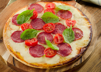 Salami Pizza served on a wooden table.