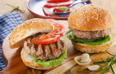 Fresh homemade burger on a wooden cutting board.